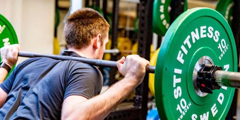 En man lyfter vikter på gym