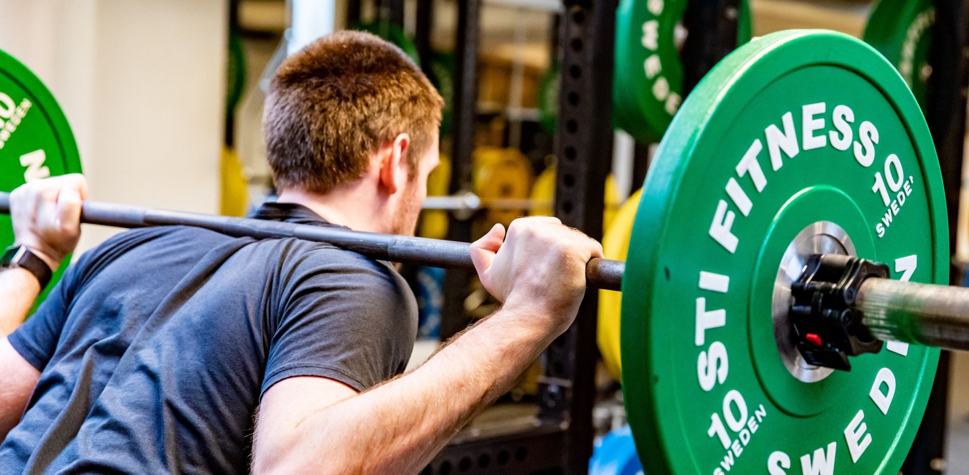 En man lyfter vikter på gym